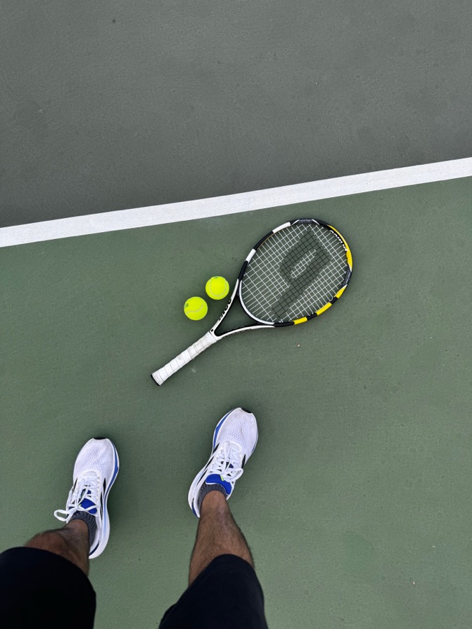 Tennis racket and shoes on court